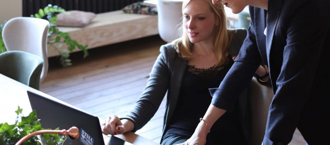 two women looking at a laptop